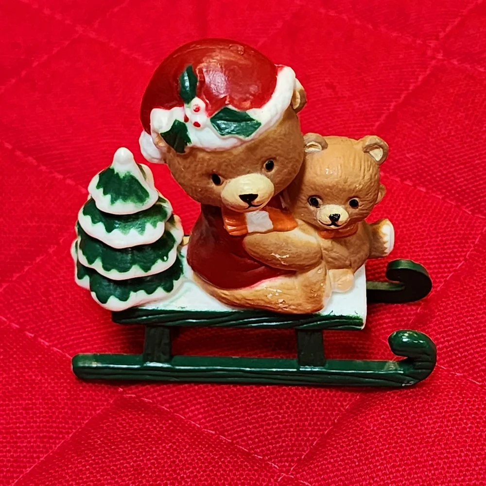 Christmas figurine featuring two teddy bears on a sled with a Christmas Tree